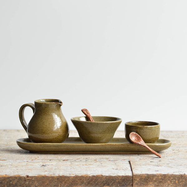 Nom Living - Handmade condiment set with a small tray, two bowls, and a jug, accompanied by two coconut palm mini spoons, featuring an deep green glaze with earthy accents.